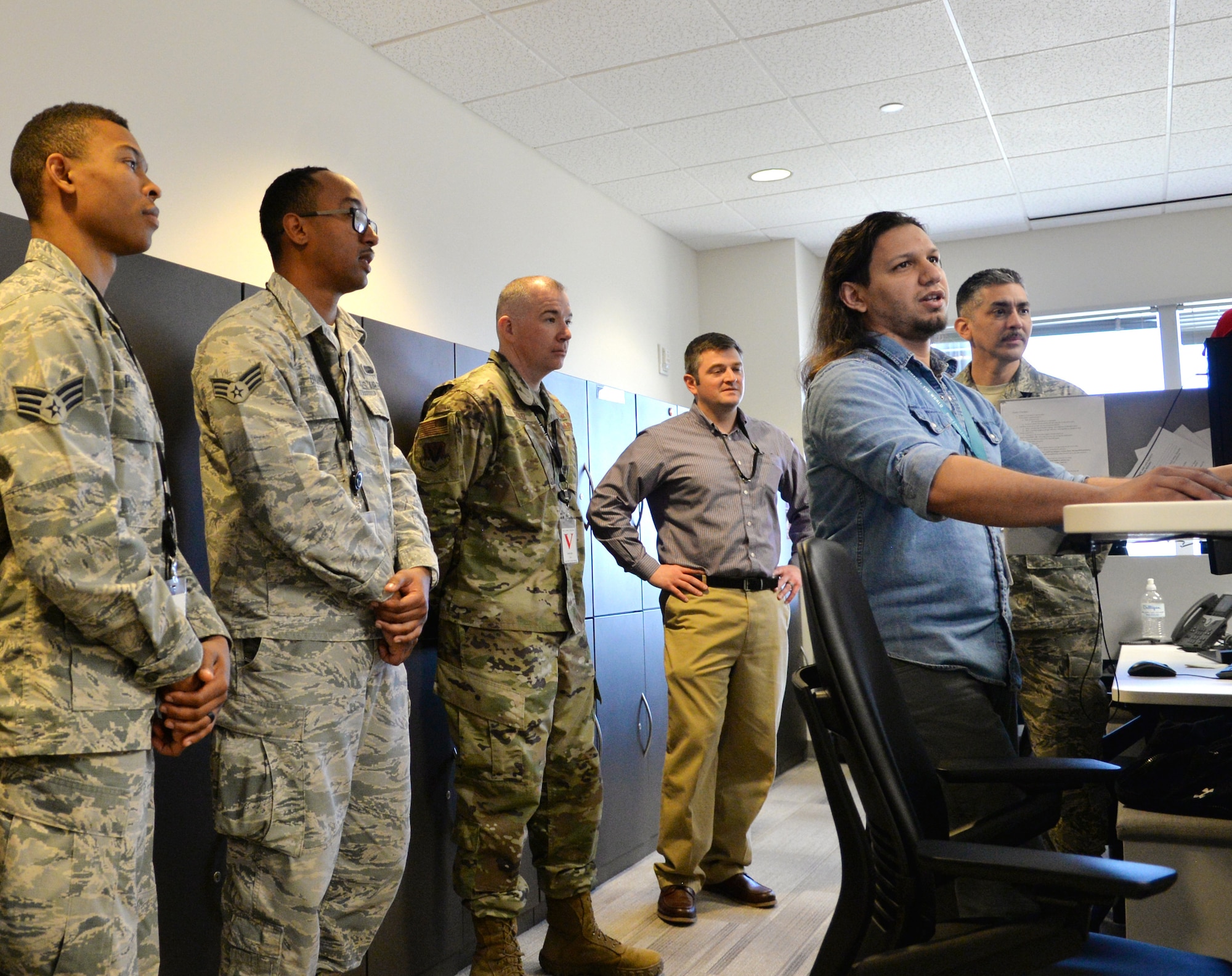 Angel Reina, Booz Allen Hamilton game technician, demonstrates a portion of virtual reality programming for members of the 55th Communications Group April 19, 2019, Omaha, Nebraska.  The development team requires an understanding of the exact requirements and steps necessary, such as work qualification skills, safety qualifications and procedures for the cable and antenna maintenance crews. (U.S. Air Force photo by D.P. Heard)