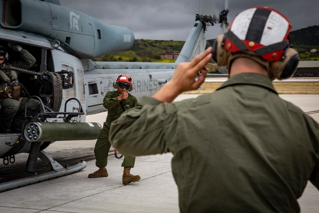 U.S. Marine Corps Lance Cpl. Isaiah Delallana (left), an aircraft ordnance technician with Marine Light Attack Helicopter Training Squadron (HMLAT) 303, Marine Aircraft Group (MAG) 39, 3rd Marine Aircraft Wing (MAW), signals to Cpl. Connor D’onofrio, an aircraft ordnance technician with HMLAT-303, MAG 39, 3rd MAW, that the ordnance is secured and ready for use during an aircraft ordnance load at Marine Corps Air Station Camp Pendleton, California, April 30, 2019. Ordnance loads are conducted regularly to support the required weapon qualifications and training of aircraft crew members and crew chiefs on the various ranges aboard Marine Corps Base Camp Pendleton. (U.S. Marine Corps photo by Cpl. Dylan Chagnon)