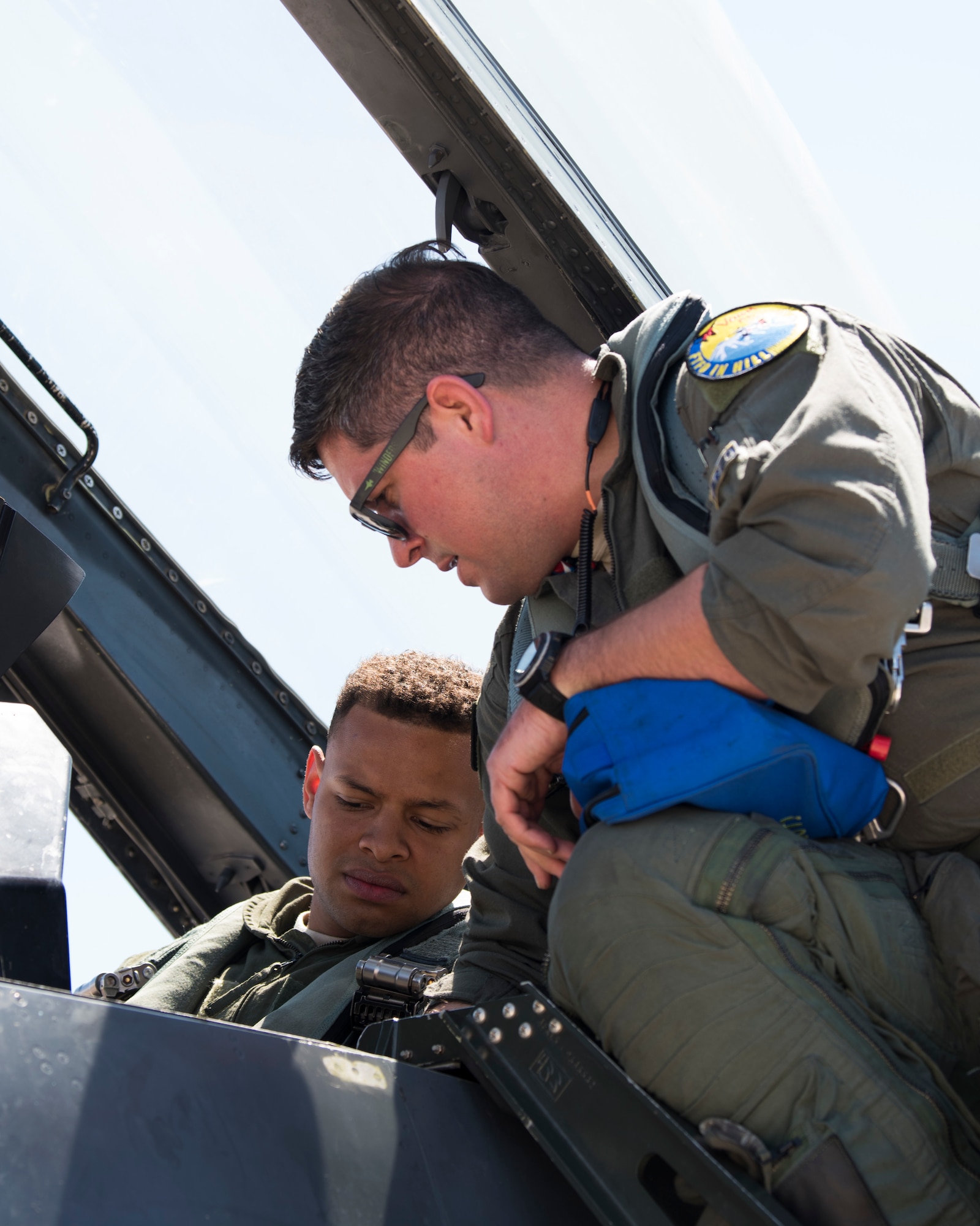 Maj. Jon Farragher, 311th Fighter Squadron assistant director of operations, helps Airman 1st Class Mequail Fridge, 311th Aircraft Maintenance Unit crew chief, buckle into the ejection seat of an F-16 Viper, April 25, 2019, on Hill Air Force Base, Utah. The 311th FS had a goal of eight familiarization flights per day for operations and maintenance personnel during exercise Venom 19-01. (U.S. Air Force photo by Staff Sgt. BreeAnn Sachs)