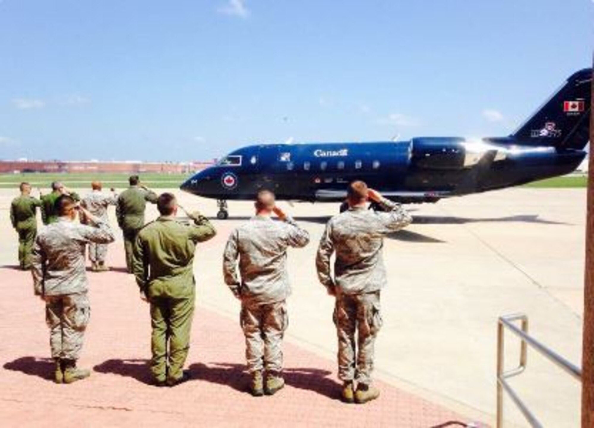 Members of the 552nd Air Control Wing and the Canadian Detachment salute as the Royal Canadian Air Force commander visits Tinker Air Force Base.