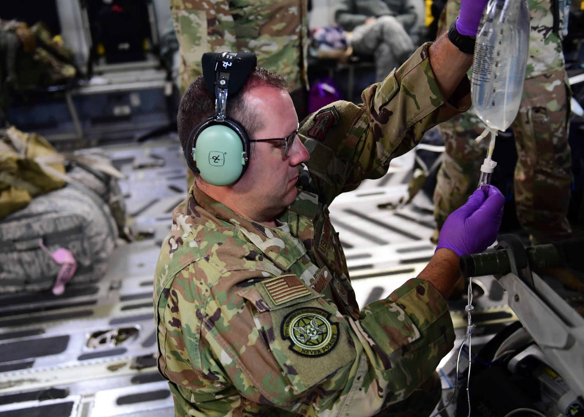 Master Sgt. Joseph Vergona, 911th Aeromedical Evacuation Squadron medical technician, sets up a saline bag near Honolulu, Hawaii April 26, 2019. As a part of the 911th AES Vergona participated in ground training as well as in air training.(U.S. Air Force Photo by Senior Airman Grace Thomson)
