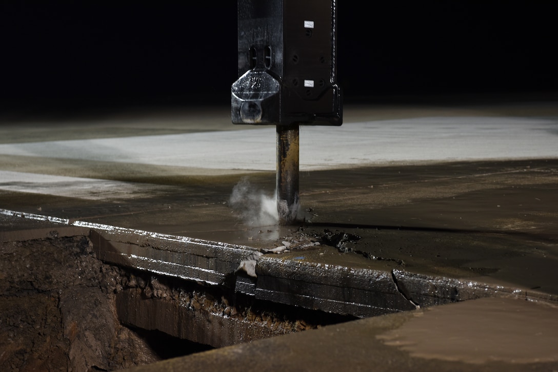 A U.S. Air Force 8th Civil Engineer Squadron member uses an excavator-mounted hydraulic jackhammer to break apart concrete at Kunsan Air Base, Republic of Korea, May 1, 2019. The 8th CES provided emergency repairs to the flight line to make it operational within 24 hours after it was closed unexpectedly due to a rupture. (U.S. Air Force photo by Staff Sgt. Joshua Edwards)