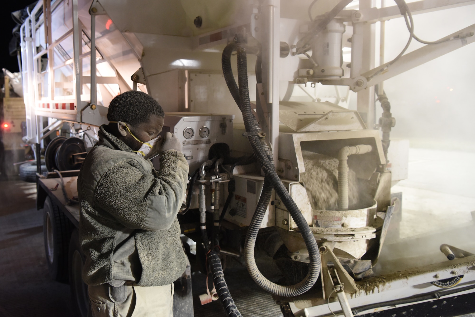 U.S. Air Force Staff Sergeant Christopher Leonard, 8th Civil Engineer Squadron pavement and construction equipment journeyman, adjusts his face mask while pouring cement at Kunsan Air Base, Republic of Korea, May 2, 2019. The 8th Civil Engineer Squadron dug out a corroded pipe that caused a rupture and restored the site in less than 24 hours. (U.S. Air Force photo by Staff Sgt. Joshua Edwards)