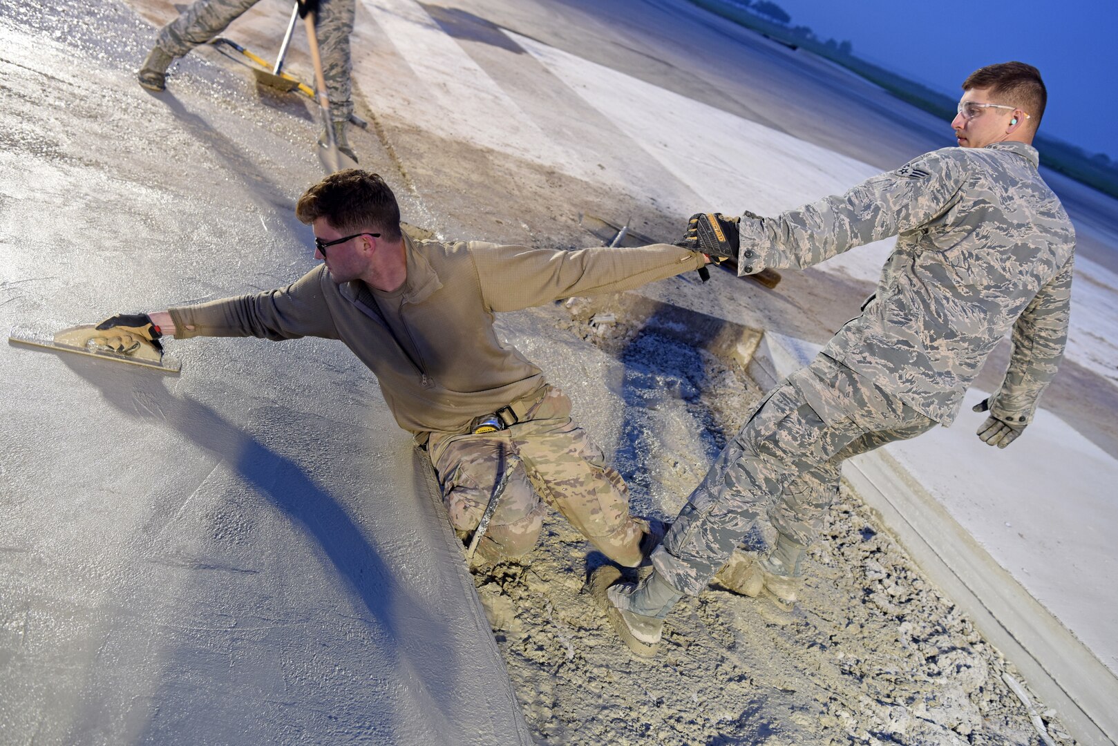 (Right) U.S. Air Force Senior Airman Steven Uhlbeck, 8th Civil Engineer Squadron pavement and construction equipment journeyman, assists Staff Sgt. Jeffrey Deptula, 8th CES, with smoothing wet concrete on the flight line at Kunsan Air Base, Republic of Korea, May 2, 2019. The 8th CES applied rapid airfield damage repair methods to fix a rupture that caused damage to the flight line. (U.S. Air Force photo by Staff Sgt. Joshua Edwards)