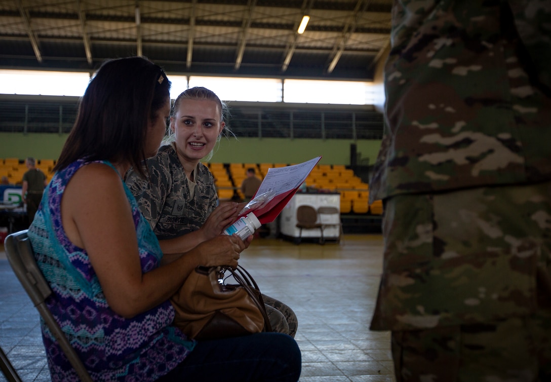 U.S. Air Force Staff Sgt. Katherine Paquette, a medical technician with 133rd Airlift Wing, speaks with a patient about her prescription at Yauco, Puerto Rico, April 30, 2019, during Innovative Readiness Training Puerto Rico. The purpose of the IRT Puerto Rico is to provide dental, optometry and medical care to the community while performing joint military humanitarian operations. Marine Forces Reserve is participating in IRT Puerto Rico 2019 in order to maintain military readiness while strengthening alliances with partners. (U.S. Marine Corps photo by Sgt. Andy O. Martinez)