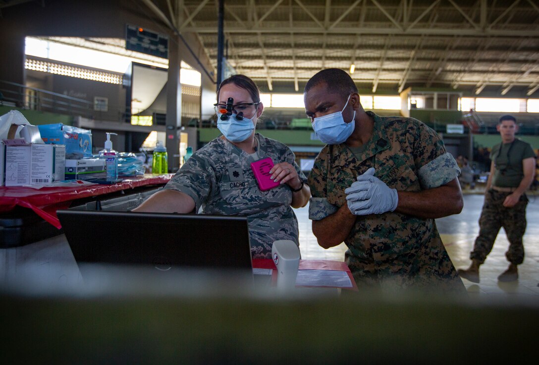 Navy Petty Officer 3rd Class Gabriel Adjetey, a hospital corpsman with 4th Dental Battalion, 4th Marine Logistics Group, Marine Forces Reserve (right), works with an Airman at Yauco, Puerto Rico, April 30, 2019, during Innovative Readiness Training Puerto Rico. The purpose of the IRT Puerto Rico is to provide dental, optometry and medical care to the community while performing joint military humanitarian operations. MARFORRES is participating in IRT Puerto Rico 2019 in order to maintain military readiness while strengthening alliances with partners. (U.S. Marine Corps photo by Sgt. Andy O. Martinez)