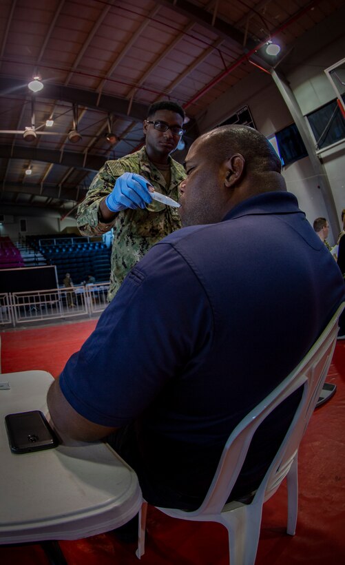 Navy Petty Officer 2nd Class Tony F. Goodwin, a hospital corpsman with Operational Health Support Unit San Diego, checks a patient’s body temperature by using a thermometer at Ponce, Puerto Rico, April 27, 2019, during Innovative Readiness Training Puerto Rico. The purpose of the Innovative Readiness Training Puerto Rico is to provide dental, optometry and medical care to the community while performing joint military humanitarian operations. Marine Forces Reserve is participating in IRT Puerto Rico 2019 in order to maintain military readiness while strengthening alliances with partners. (U.S. Marine Corps photo by Sgt. Andy O. Martinez)