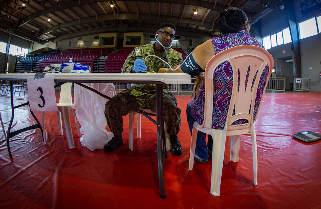 Navy Petty Officer 2nd Class Tony F. Goodwin, a hospital corpsman with Operational Health Support Unit San Diego, checks a patient’s body temperature by using a thermometer at Ponce, Puerto Rico, April 27, 2019, during Innovative Readiness Training Puerto Rico. The purpose of the Innovative Readiness Training Puerto Rico is to provide dental, optometry and medical care to the community while performing joint military humanitarian operations. Marine Forces Reserve is participating in IRT Puerto Rico 2019 in order to maintain military readiness while strengthening alliances with partners. (U.S. Marine Corps photo by Sgt. Andy O. Martinez)