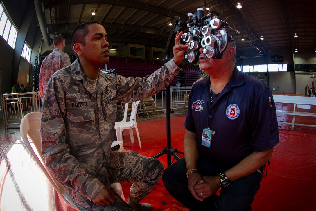 An Airman uses an illuminated phoropter refracting instrument to check a patient’s vision at Ponce, Puerto Rico, April 27, 2019, during Innovative Readiness Training Puerto Rico. The purpose of the Innovative Readiness Training Puerto Rico is to provide dental, optometry and medical care to the community while performing joint military humanitarian operations. Marine Forces Reserve is participating in IRT Puerto Rico 2019 in order to maintain military readiness while strengthening alliances with partners. (U.S. Marine Corps photo by Sgt. Andy O. Martinez)