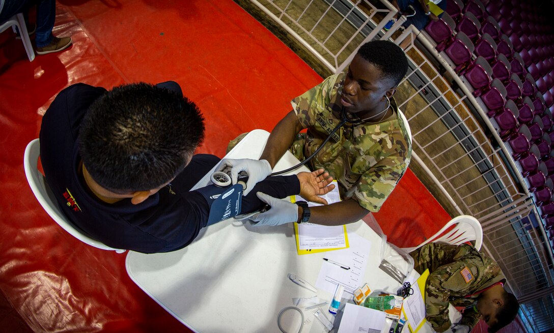 An Army Soldier checks a patient’s blood pressure at Ponce, Puerto Rico, April 27, 2019, during Innovative Readiness Training Puerto Rico. The purpose of the Innovative Readiness Training Puerto Rico is to provide dental, optometry and medical care to the community while performing joint military humanitarian operations. Marine Forces Reserve is participating in IRT Puerto Rico 2019 in order to maintain military readiness while strengthening alliances with partners. (U.S. Marine Corps photo by Sgt. Andy O. Martinez)