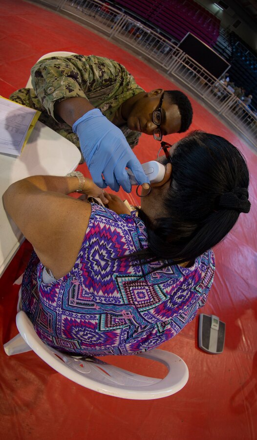 Navy Petty Officer 2nd Class Tony F. Goodwin, a hospital corpsman with Operational Health Support Unit San Diego, checks a patient’s body temperature by using an ear thermometer at Ponce, Puerto Rico, April 27, 2019, during Innovative Readiness Training Puerto Rico. The purpose of the Innovative Readiness Training Puerto Rico is to provide dental, optometry and medical care to the community while performing joint military humanitarian operations. Marine Forces Reserve is participating in IRT Puerto Rico 2019 in order to maintain military readiness while strengthening alliances with partners. (U.S. Marine Corps photo by Sgt. Andy O. Martinez)
