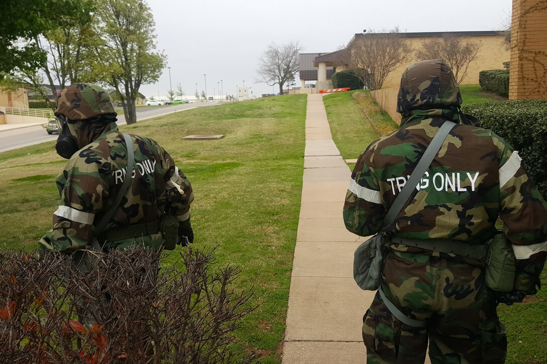 Two soldiers walk along a sidewalk.