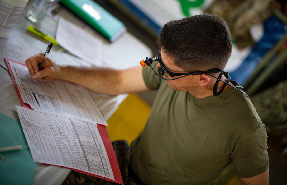 U.S. Navy Lt. Cmdr. Jason Morris, an orthodontist with 4th Dental Battalion, 4th Marine Logistics Group, Marine Forces Reserve, fills out a form for a patient at Yauco, Puerto Rico, April 28, 2019, during Innovative Readiness Training Puerto Rico. IRT Puerto Rico is also called Ola de Esperanza Sanadora, which translates to Healing Wave of Hope. This IRT is part of a civil and joint military program to improve military readiness while simultaneously providing quality services to underserved communities throughout the United States. (U.S. Marine Corps photo by Sgt. Andy O. Martinez)