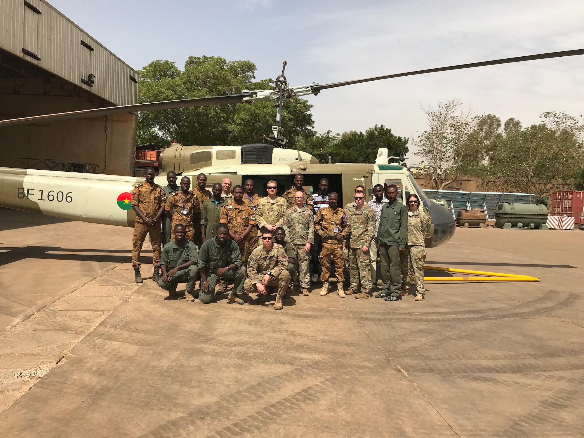 Members from the 818th Mobility Support Advisory Squadron pose for a group photo at Airbase 511 in Burkina Faso, Africa, April 18, 2019. The 818th MSAS sent a seven member Rotary Wing Maintenance and Operations mobile training team to identify the cause of a significant maintenance issue that had grounded the Burkina Faso Air Force’s UH-1H helicopter fleet for nearly a year. (U.S. Air Force photo by Master Sgt. Sarah Colwell)