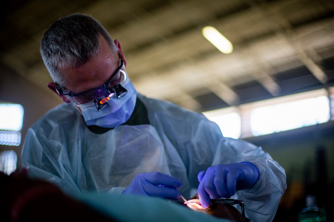 U.S. Navy Lt. Cmdr. Kevin Smith, a general dentist with 4th Dental Battalion, 4th Marine Logistics Group, Marine Forces Reserve, examines a patient’s teeth at Yauco, Puerto Rico, April 28, 2019, during Innovative Readiness Training Puerto Rico. IRT Puerto Rico is also called Ola de Esperanza Sanadora, which translates to Healing Wave of Hope. This IRT is part of a civil and joint military program to improve military readiness while simultaneously providing quality services to underserved communities throughout the United States. (U.S. Marine Corps photo by Sgt. Andy O. Martinez)
