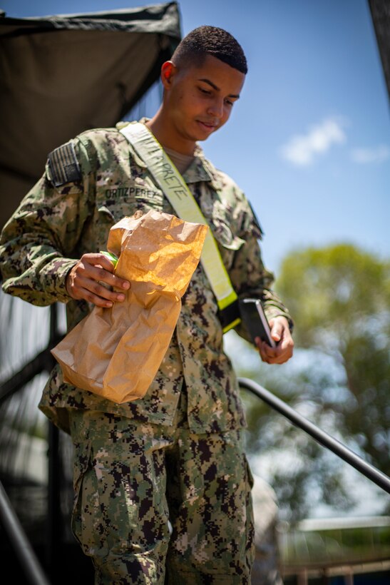 A U.S. Navy Sailor picks up a bag lunch at Yauco, Puerto Rico, April 28, 2019, during Innovative Readiness Training Puerto Rico. IRT Puerto Rico is also called Ola de Esperanza Sanadora, which translates to Healing Wave of Hope. This IRT is part of a civil and joint military program to improve military readiness while simultaneously providing quality services to underserved communities throughout the United States. (U.S. Marine Corps photo by Sgt. Andy O. Martinez)