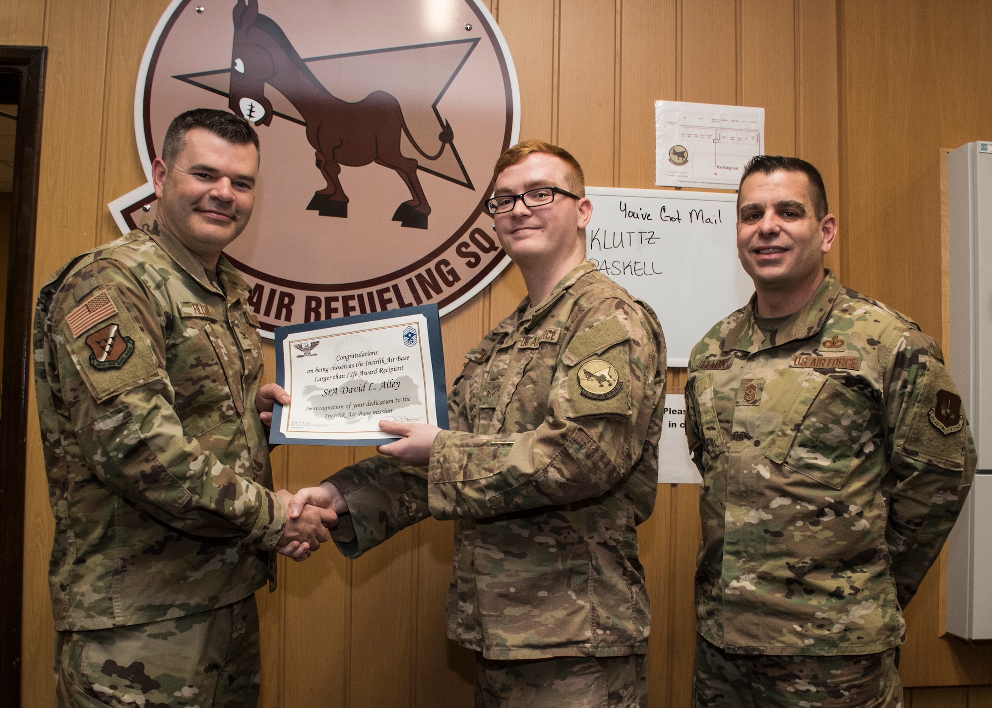 Col. Brian A. Filler, 39th Air Base Wing vice commander, left, and Chief Master Sgt. Jason T. Heilman, 39th ABW command chief, right, present the deployed Larger than Life Award to Senior Airman David Alley, 22nd Expeditionary Air Refueling Squadron weather forecaster, Apr. 25, 2019, at Incirlik Air Base.