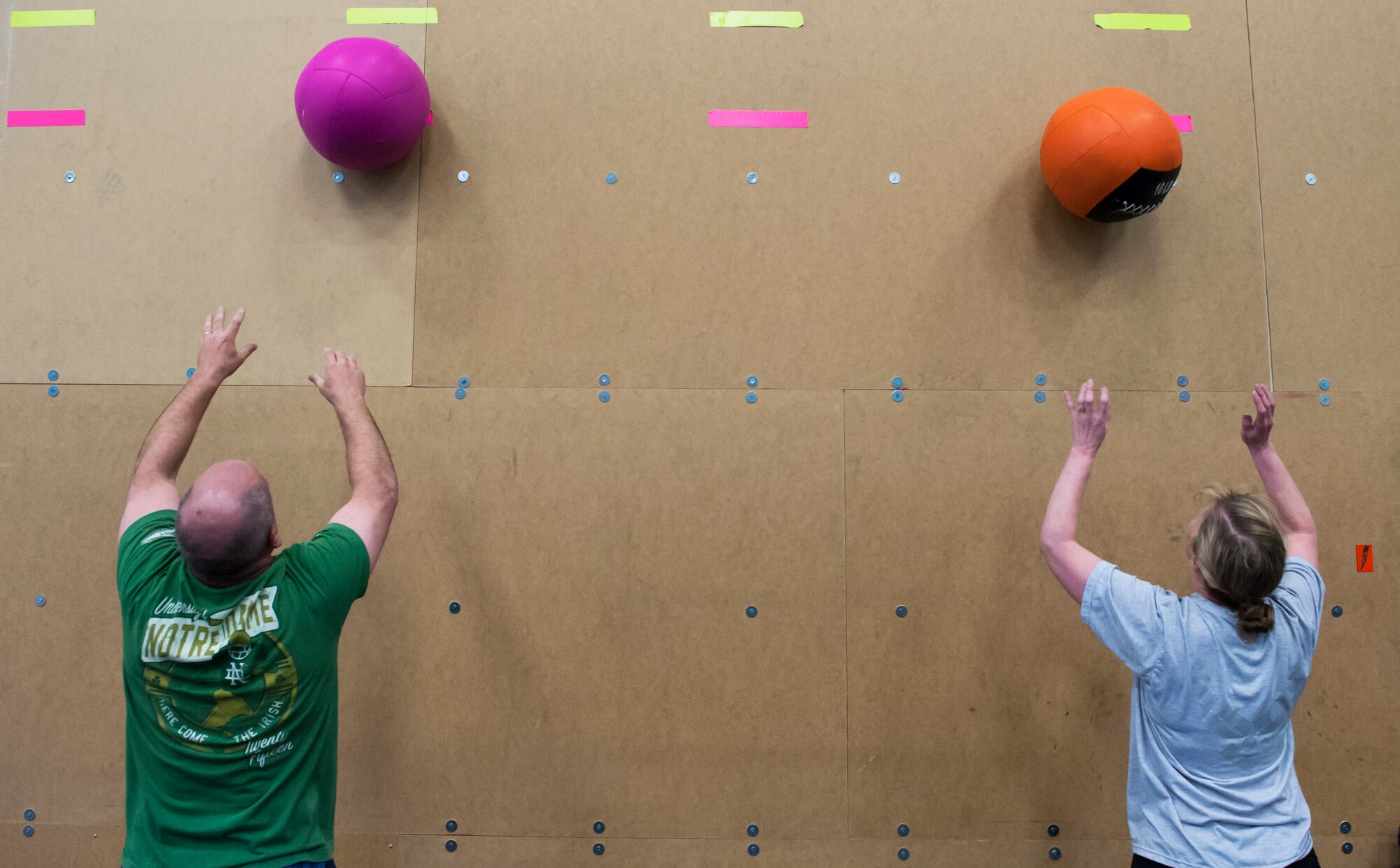 Conn Mckelvey, 341st Contracting Squadron contracting specialist, and Chief Master Sgt.  Minnette Bohlander, 341st Missile Maintenance Squadron superintendent, perform wall ball squats during a “Wing One” fitness class April 29, 2019, at Malmstrom Air Force Base, Mont.