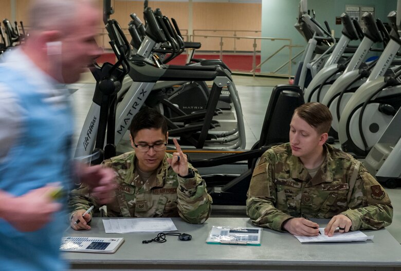 Tech Sgt. Luis Escobar and Staff Sgt. Mark Pulley, 341st Force Support Squadron Fitness supervisors, administer the 1.5-mile run portion of the Air Force physical fitness assessment April 26, 2019, at Malmstrom Air Force Base, Mont.