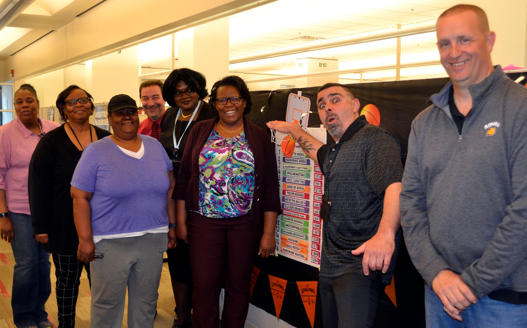 Teammates from DLA Troop Support Industrial Hardware and members of PR Madness’ third place finishers, “Hardware’s Last Stand,” pose in front of this year’s PR Madness leaderboard May 1, 2019 in Philadelphia.