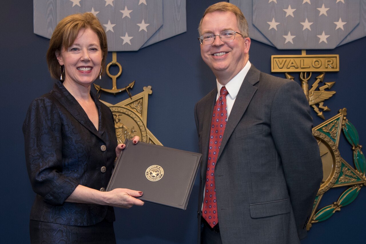 A man and woman smile after an awards presentation.