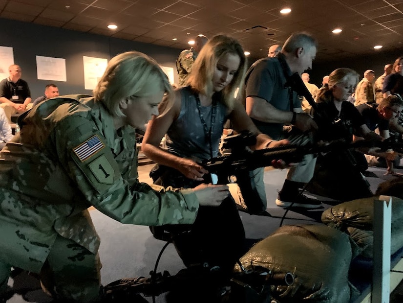 Mrs. Melissa Friez is the Assistant Superintendent of Student Support Services in the Pittsburgh public schools district. Col. Dina Wandler, Commander 1st Recruiting Brigade, shows Friez how to load an M4 rifle during a visit to the engagement skills trainer at the Army Educator Tour.