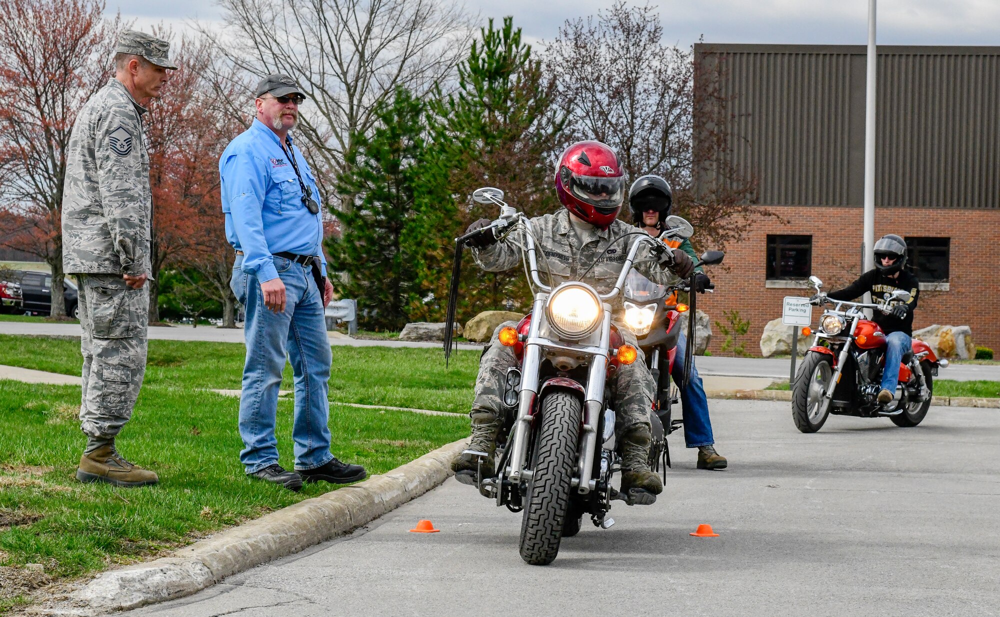 Andy Ford, occupational safety manager assigned to the 910th Airlift Wing, and Master Sgt. Phil Walsh, aircrew flight supervisor assigned to the 910th Operations Support Squadron, observe motorcycle safety course participants on April 12, 2019, at a parking lot in YARS.