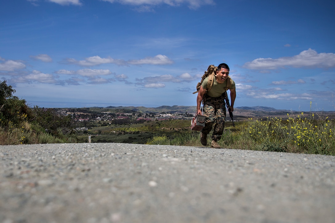 A Marine hikes up a hill.