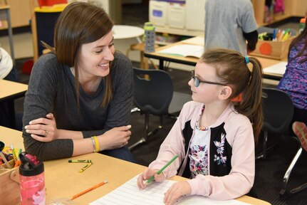 1st Lt. Ashley Chapa, director of equal opportunity, assigned to the Ohio National Guard’s 180th Fighter Wing, assists first grader Olivia Boylan with story writing at Liberty Center Elementary School where she works as an intervention specialist with the school’s special education program.