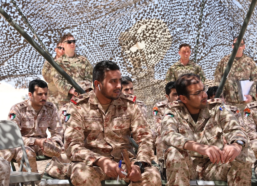 Kuwait Land Forces (KLF) Lt. Col. Ahmad Alsanea, middle, and other KLF soldiers observe a sand table rehearsal for a situational training exercise conducted by U.S. Soldiers from 3rd Battalion, 29th Artillery Regiment, 3rd Armored Brigade Combat Team, 4th Infantry Division, at a Camp Buehring, Kuwait training area on April 23, 2019. Alsanea and his Soldiers trained with their U.S. counterparts as part of an enduring partnership that enables interoperability between regional allies.