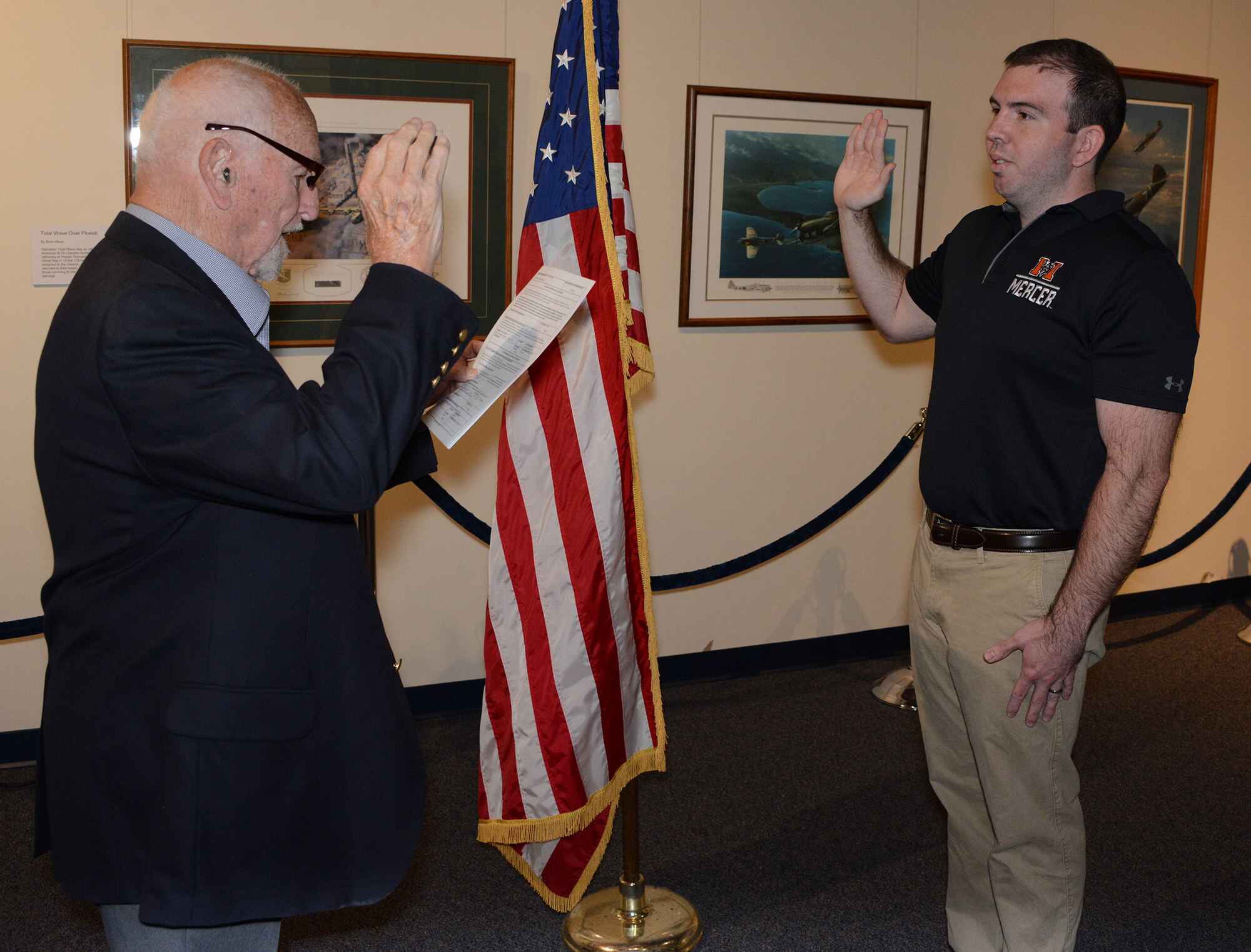 Ramon Carpenter, a retired United States Naval aviator, does the commissioning oath for his grandson, Garren "Ridge" Belflower at the Museum of Aviation at Robins Air Force Base, Georgia. Belflower joins a long list of family members who have served in the United States military. (Air Force photo/Master Sgt. Chance Babin)