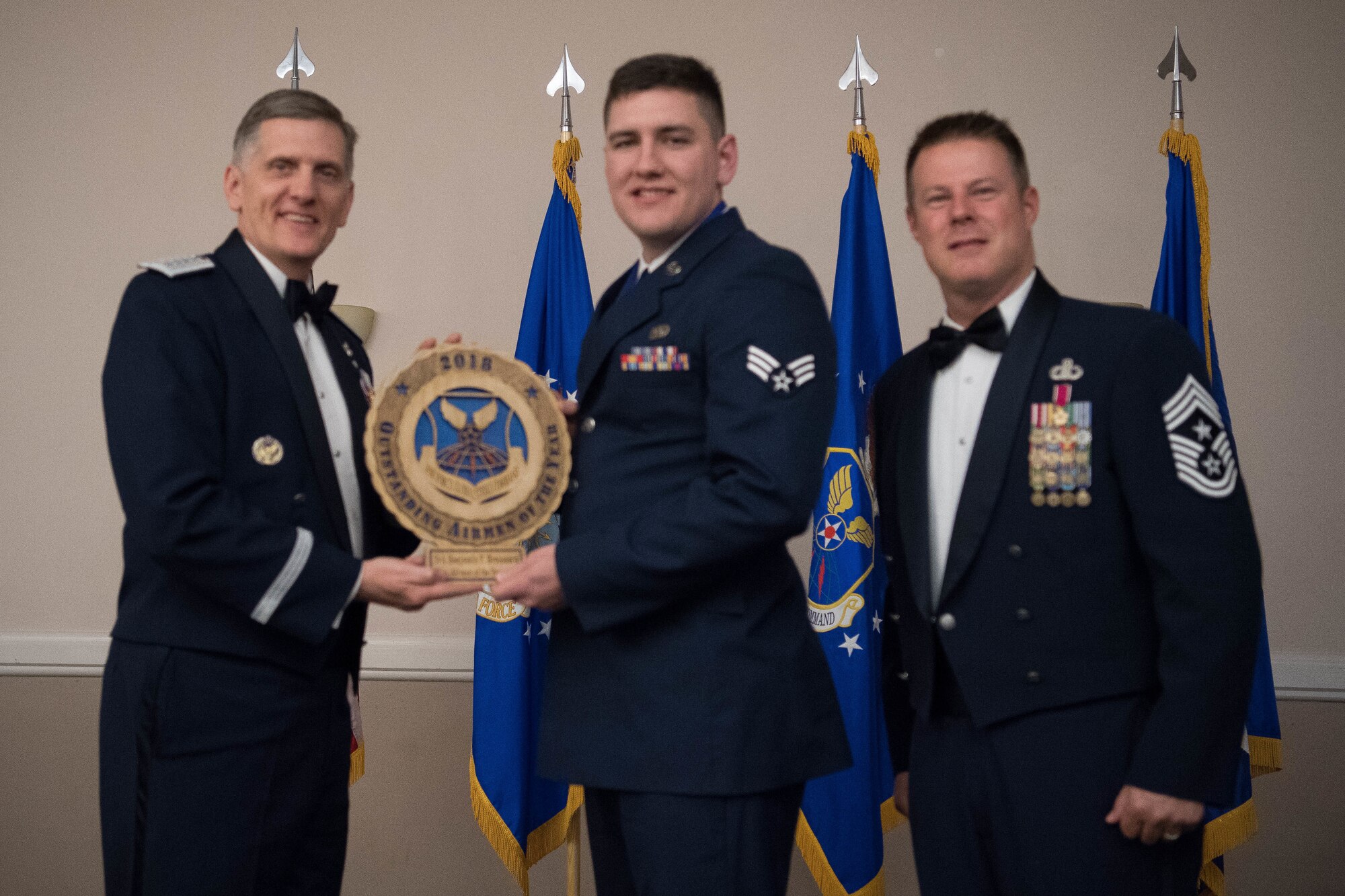 U.S. Air Force Senior Airman Benjamin P. Broussard (middle), 28th Operations Support Squadron, target analyst at Ellsworth Air Force Base, S.D., receives an Air Force Global Strike Command Outstanding Airmen of the Year award April 15, 2019, at Barksdale Air Force Base, La. The OAY award was awarded to six Airmen throughout AFGSC. (U.S. Air Force photo by Airman Jacob B. Wrightsman)