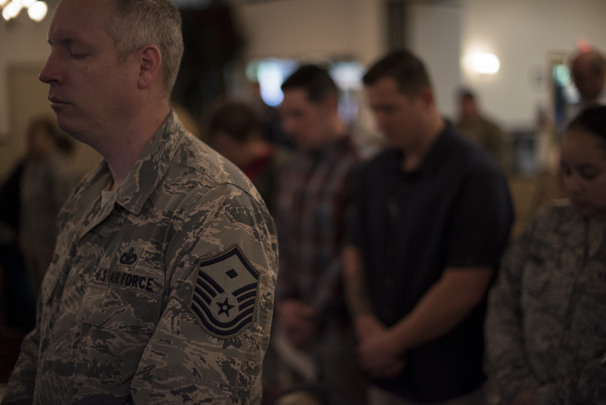 An Airman stands in prayer during an invocation at the 2019 A Day of Remembrance ceremony on Joint Base McGuire-Dix-Lakehurst, New Jersey, April 30, 2019.  The ceremony focuses on remembering those who suffered through the Holocaust. (U.S. Air Force photo by Airman 1st Class Ariel Owings)
