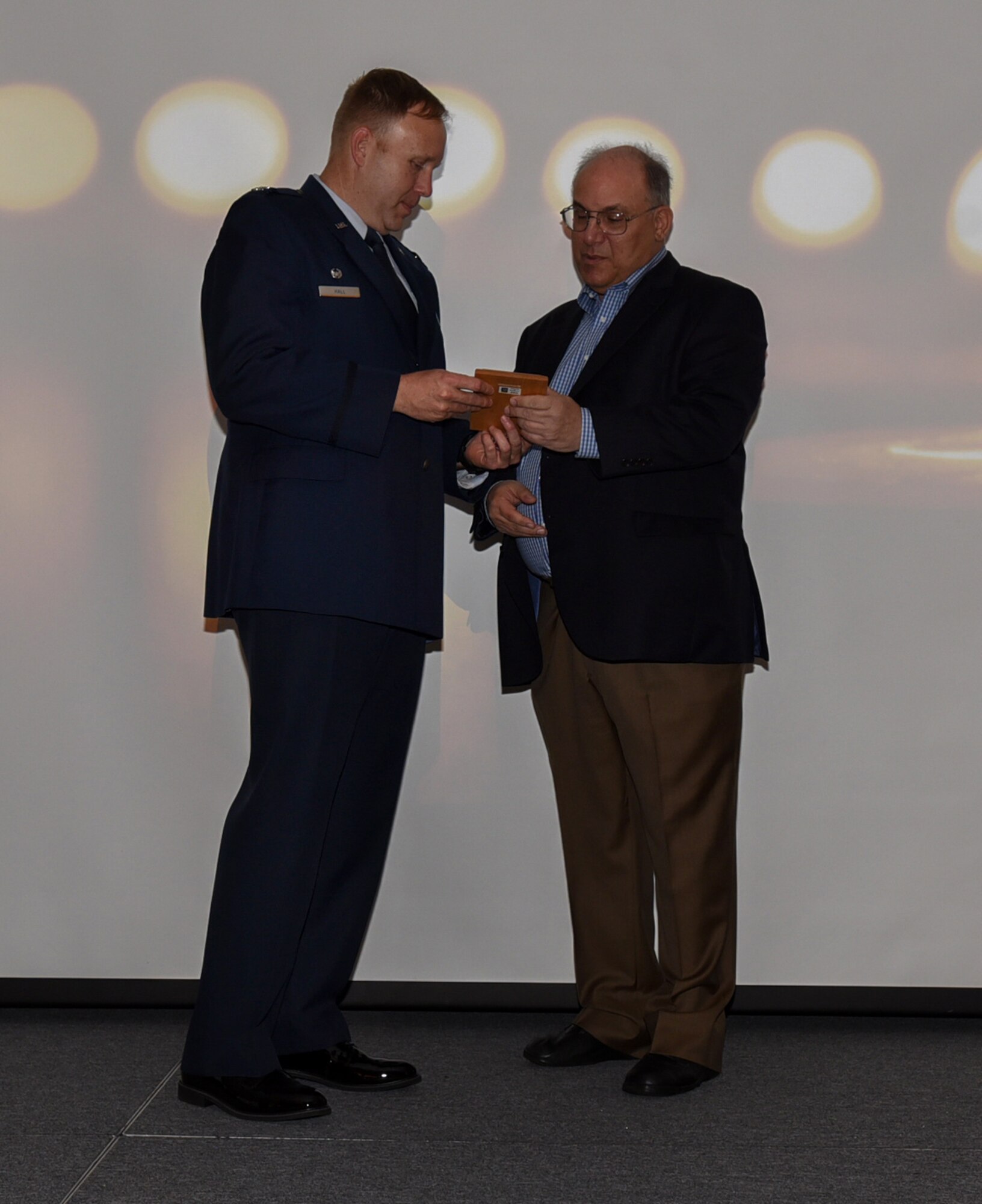 U.S. Air Force Col. James Hall, 621st Contingency Response Wing commander, presents an award to Phil Kirschner, New Jersey Commission on Holocaust Education chairman, during the 2019 A Day of Remembrance ceremony on Joint Base McGuire-Dix-Lakehurst, New Jersey, April 30, 2019. Kirschner was the guest speaker during the ceremony and discussed what happened to his parents and their families during Holocaust and how they met. (U.S. Air Force photo by Airman 1st Class Ariel Owings)