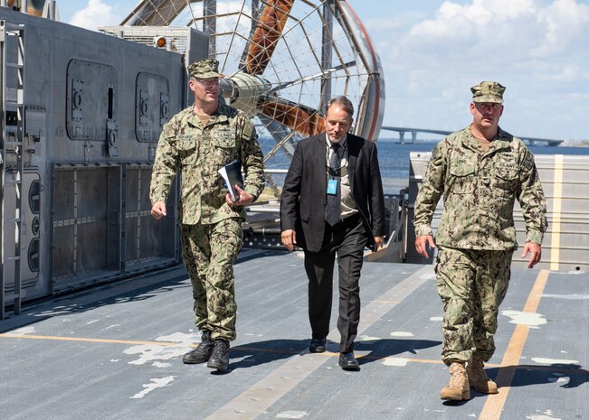 Dave Vickers, Expeditionary Systems Division head, and Master Chief Petty Officer Stephen Lowe, gas turbine system technician, give Commander, Naval Sea Systems Command Warfare Centers Rear Adm. Eric Ver Hage, a tour of a Landing Craft Air Cushion during his tour of Naval Surface Warfare Center Panama City Division May 1.