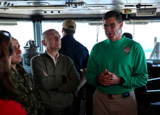 Rear Adm. John Wade, commander, Carrier Strike Group 12 (left), greets President Ilir Meta of Albania, on the flight deck of the Nimitz-class aircraft carrier USS Abraham Lincoln (CVN 72).