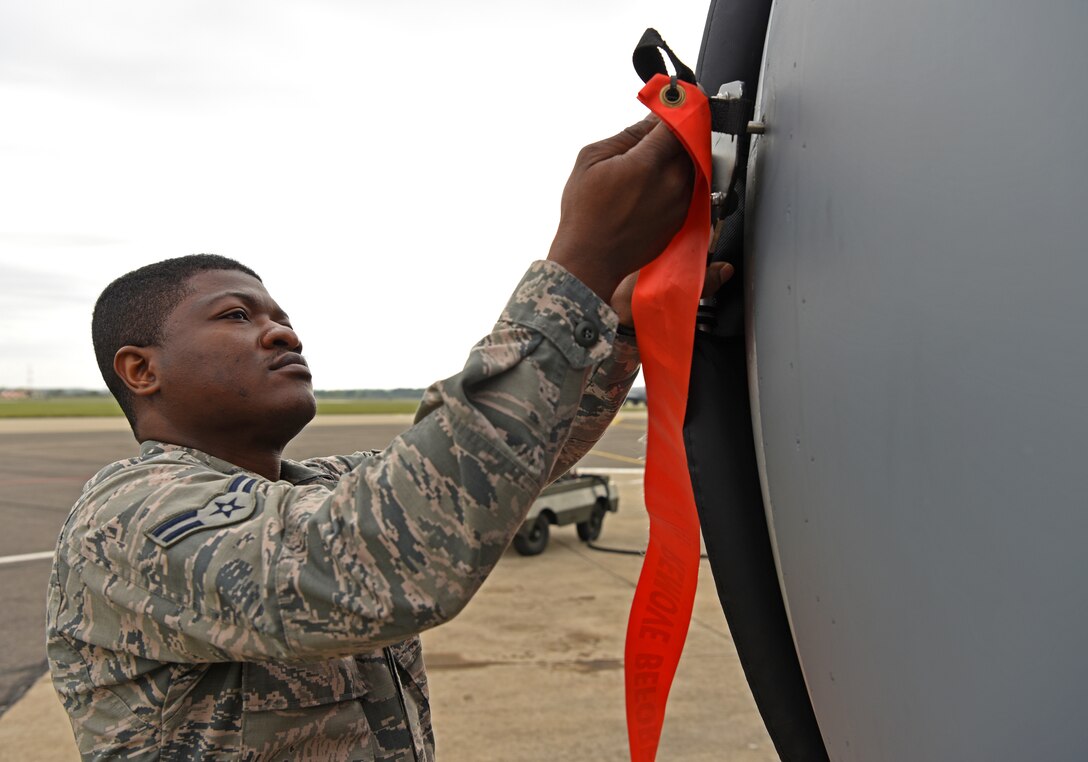 U.S. Air Force Airman 1st Class Michael Ayitiah, 100th Aircraft Maintenance crew chief apprentice, removes an engine cover at RAF Mildenhall, England, May 2, 2019.  Airmen are put through a training program, called Phase I, where they are put in classroom and flight line settings as part of upgrade training. (U.S. Air Force photo by Airman 1st Class Brandon Esau)