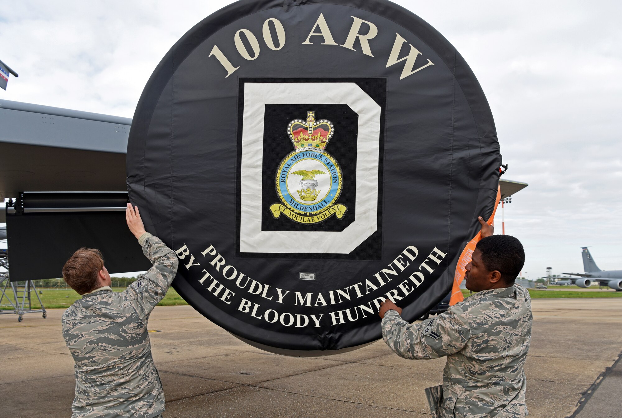 U.S. Air Force Airman 1st Class Chandra Beratto and Airman 1st Class Michael Ayitiah, 100th Aircraft Maintenance Squadron crew chief apprentices, remove an engine cover at RAF Mildenhall, England, May 2, 2019. During upgrade training, Airmen must complete tasks such as the recovery of aircraft, call flight controls prior to a launch and marshaling aircraft. (U.S. Air Force photo by Airman 1st Class Brandon Esau)