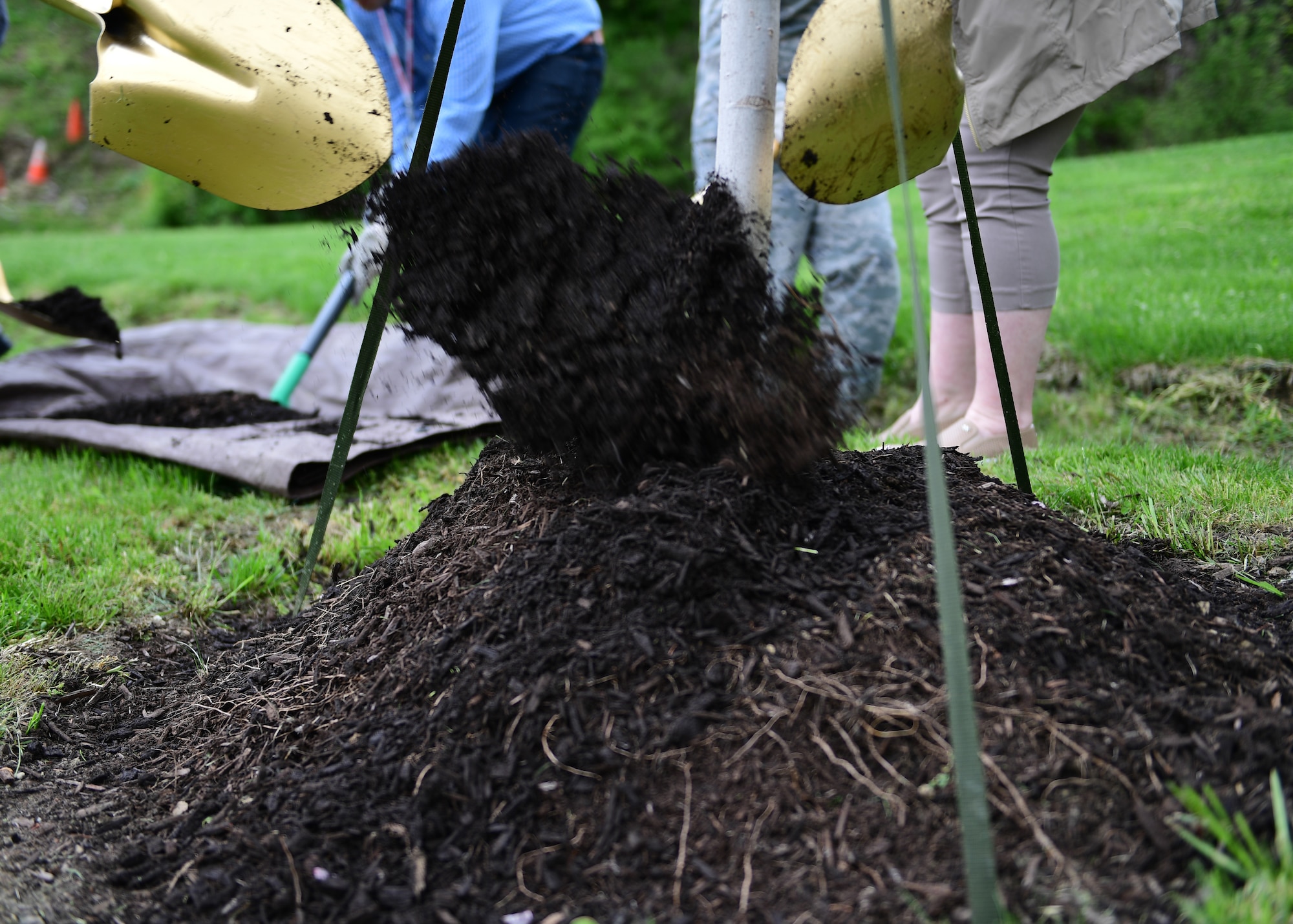 Personnel assigned to the 911th Airlift Wing, shovel fresh soil onto a tree at the Pittsburgh International Airport Air Reserve Station, Pennsylvania, May 2, 2019. The Earth Day celebrations started with the tree planting ceremony and continued later in the day when a member of the Penn State Extension Master Gardeners taught members how to make newspaper plant pots. (U.S. Air Force Photo by Senior Airman Grace Thomson)