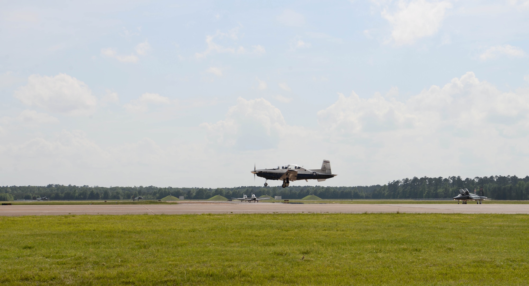 A T-6 Texan ll descends to land on the center runway May 1, 2019, on Columbus Air Force Base, Mississippi. Student pilots practice takeoff and landing techniques as a part of the exercises for getting in their own flying hours to progress in the next phase of training. (U.S. Air Force photo by Airman 1st Class Jake Jacobsen)
