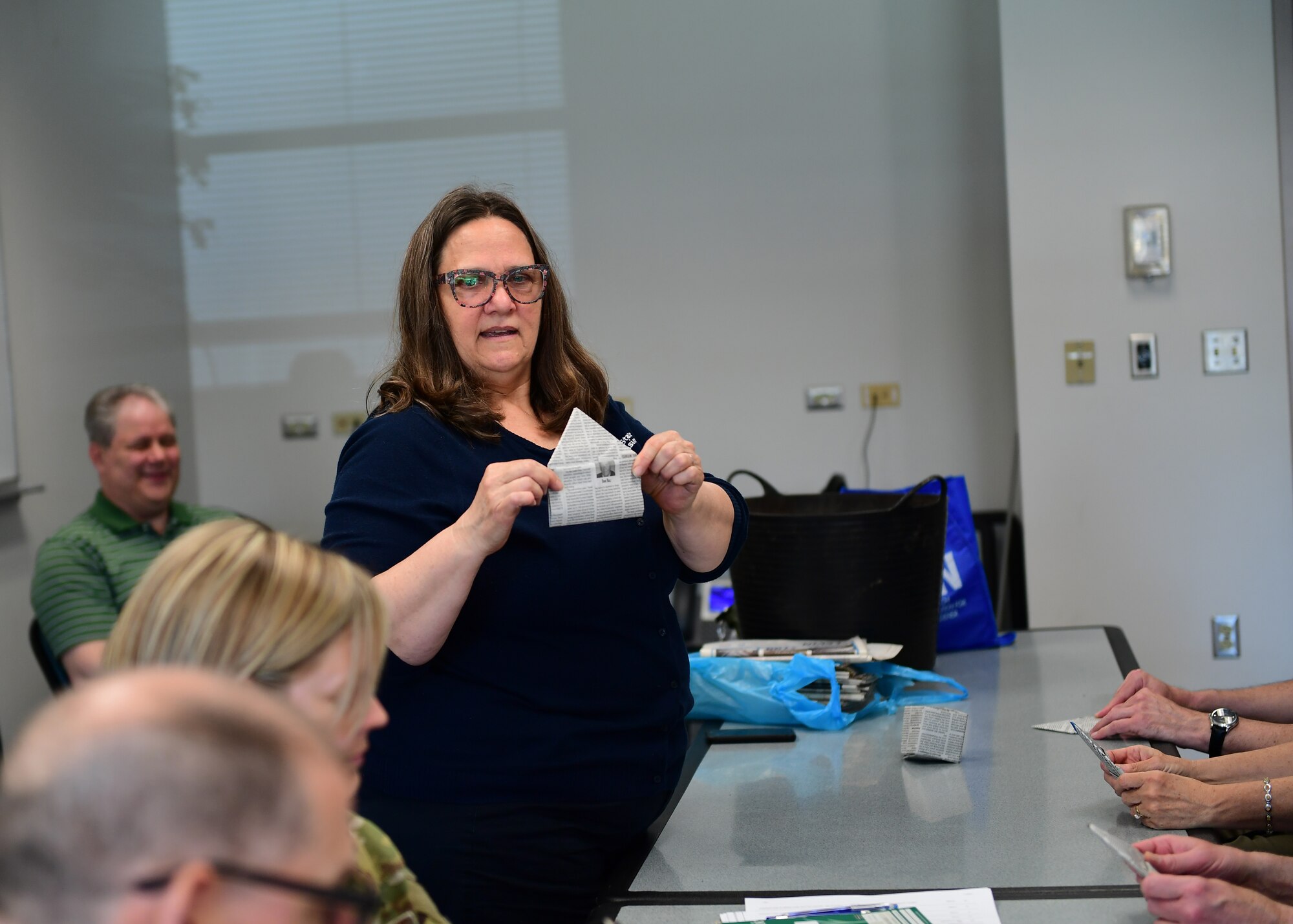 Laura Delach, Penn State Extension Office master gardener, demonstrates how the folds should look at the Pittsburgh International Airport Air Reserve Station, Pennsylvania, May 2, 2019. The newspaper’s are decomposable, which allows the plants to be placed in a new pot once the plant has matured. (U.S. Air Force Photo by Senior Airman Grace Thomson)