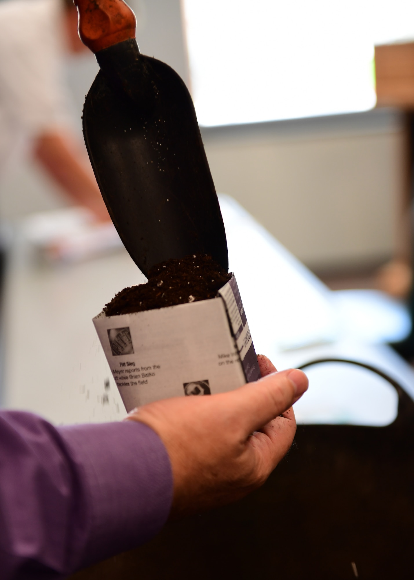 James Rasmussen, 911th Mission Support Group industrial hygienist, fills newspaper pot with soil at the Pittsburgh International Airport Air Reserve Station, Pennsylvania, May 2, 2019. Each attendee had the opportunity to take soil and seeds to grow at their own leisure. (U.S. Air Force Photo by Senior Airman Grace Thomson)