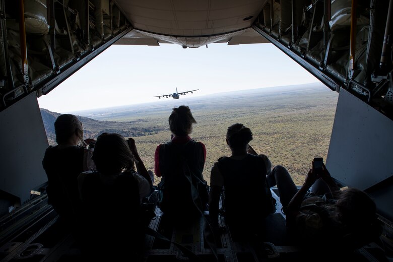Military spouses sit on the back of an MC-130J Commando II