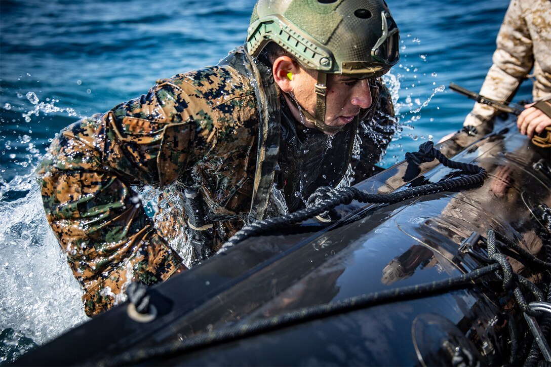 A Marine boards a combat rubber raiding craft.