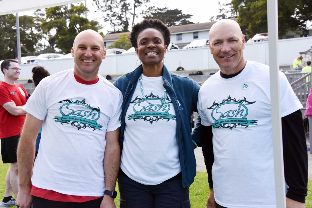 Army Col. Gary Hausman, Commandant of Defense Language Institute Foreign Language Center, Dawn Holmes, a sexual assault prevention and response victim advocate at DLIFLC, and Thomas Donehue, Command Sgt. Maj. of DLIFLC stand on Soldier Field before the Teal Run April 24, 2019. The Teal Run is sponsored by the Sexual Harassment/Assault Response and Prevention office at DLIFLC. (Courtesy photo)