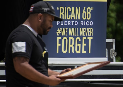Luis Espada, brother of Senior Airman Roberto Espada, reads a plaque presented to him by officials from the city of Port Wentworth, GA, at the “Rican 68” memorial service May 2, 2019.