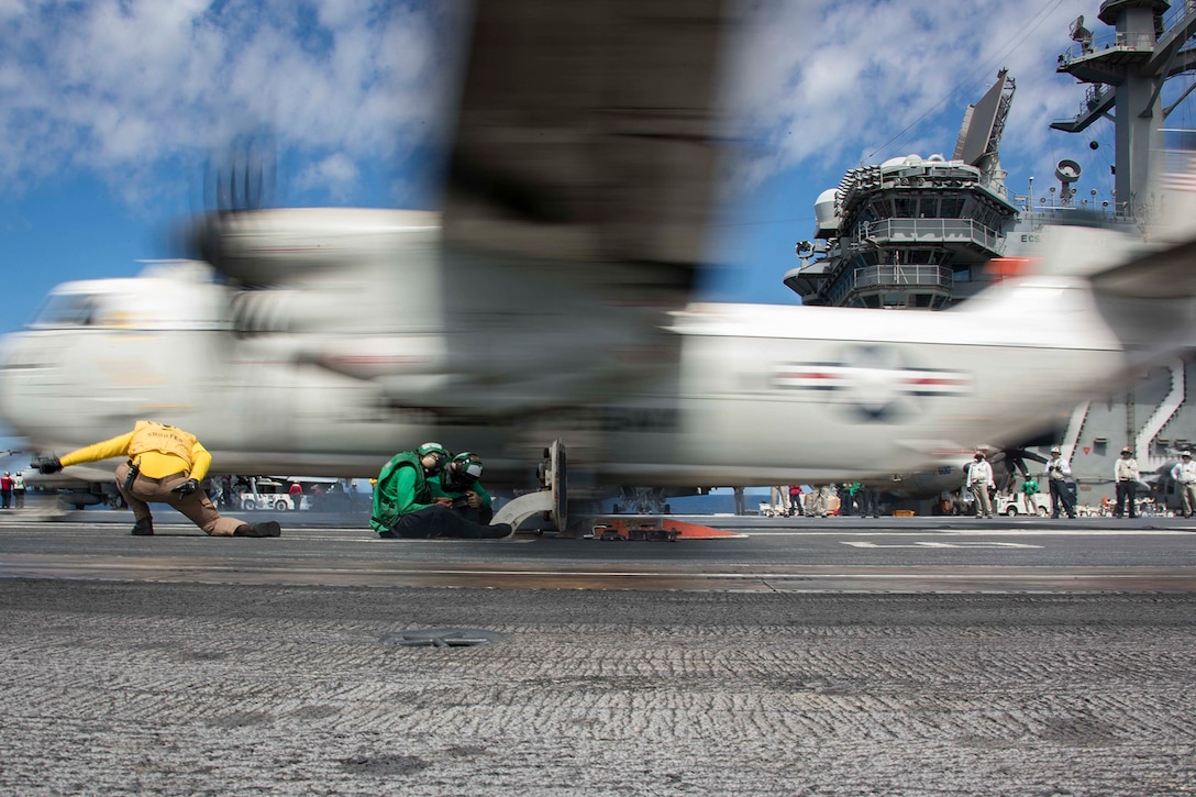 Sailors launch an aircraft from an aircraft carrier.