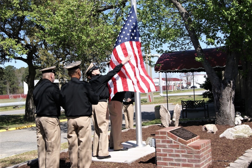 A United States Navy color guard carefully handles the American flag at the flag-raising ceremony at Joint Expeditionary Base Little Creek-Fort Story, Virginia, April 1, 2019, in honor of Master Chief Carl Brashear, who became the first African-American to attend and graduate from the U.S. Navy Diving & Salvage training school.  The site of the Official US Navy Chief Petty Officers Club is dedicated as a memorial to Brashear - the first African-American U.S. Navy diver - in honor of his strength, courage, determination, and the power of a can-do attitude and spirit.