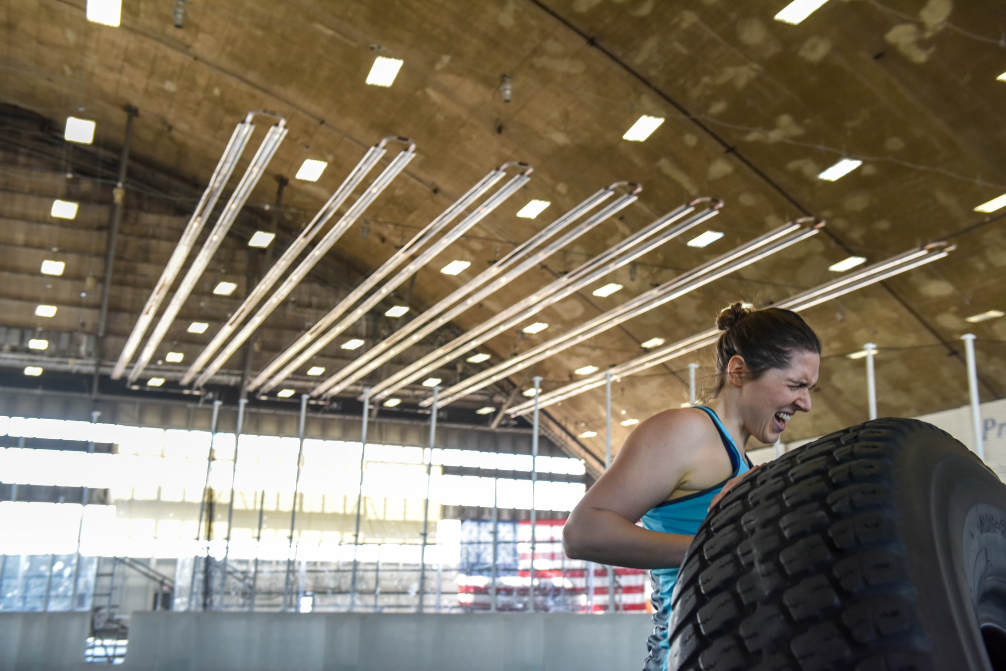 Eugene Weaver, a military spouse, flips a tire down the Pride Hangar’s turf field during the Ellsworth Air Force Base’s Strongest Competition on Ellsworth AFB, S.D., April 25, 2019. The free sporting event was hosted by the 28th Force Support Squadron. Competitors performed feats of strength throughout five different exercises: max-out deadlift, farmer’s carry, keg run, tire flip and vehicle pull. Weaver placed third in the strongest female category. (U.S. Air Force photo by Tech. Sgt. Jette Carr)