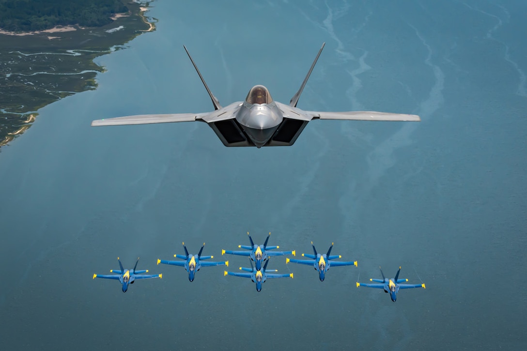 Blue Angels fly with an F-22 aircraft.